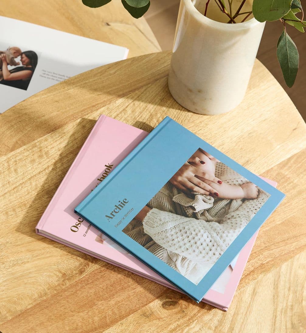 Pink and blue hardcover photo books of a baby's first year