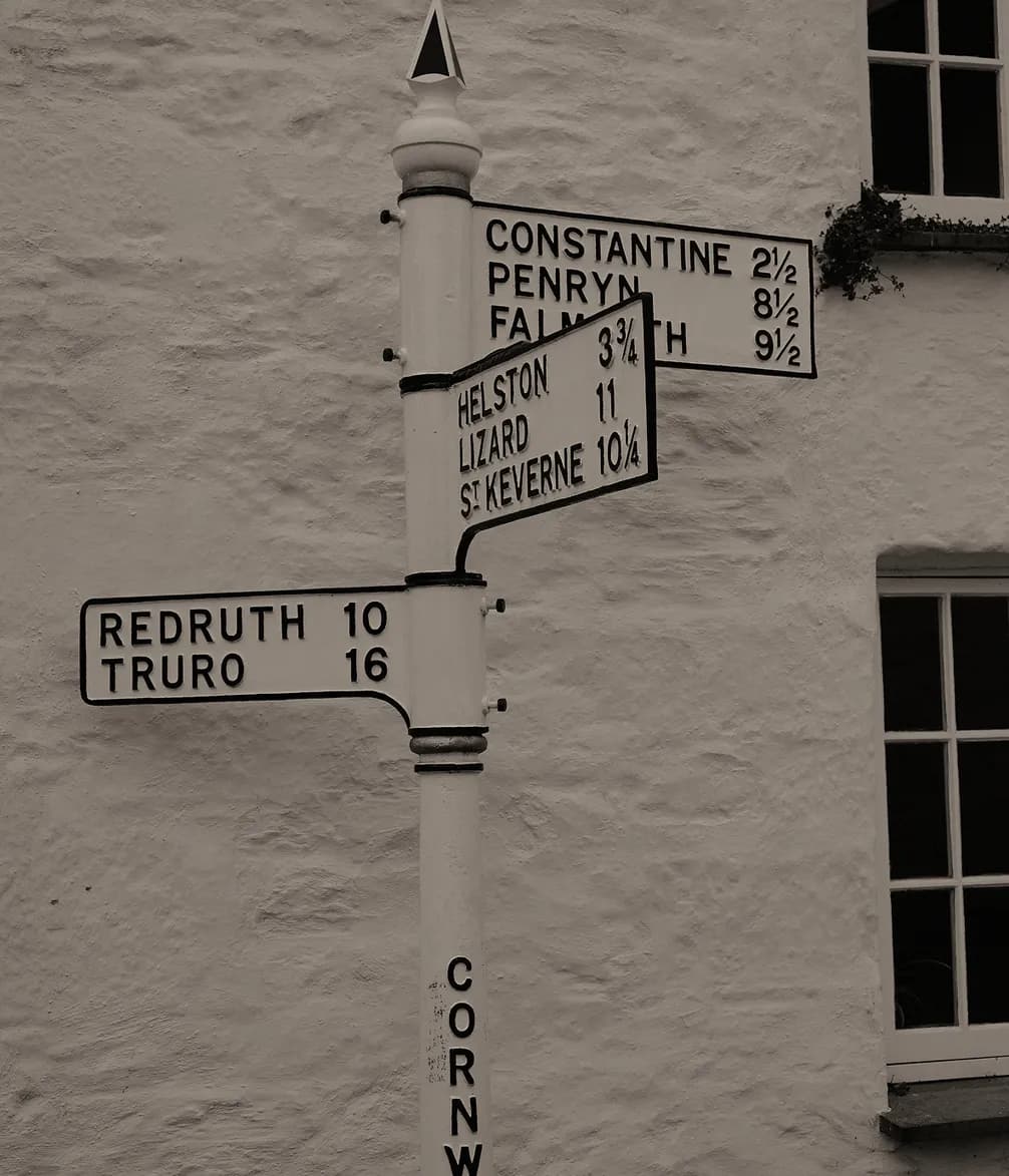 A vintage road signpost in Cornwall, with directions to Constantine, Penryn, Falmouth, Helston, Lizard, St. Keverne, Redruth, and Truro.