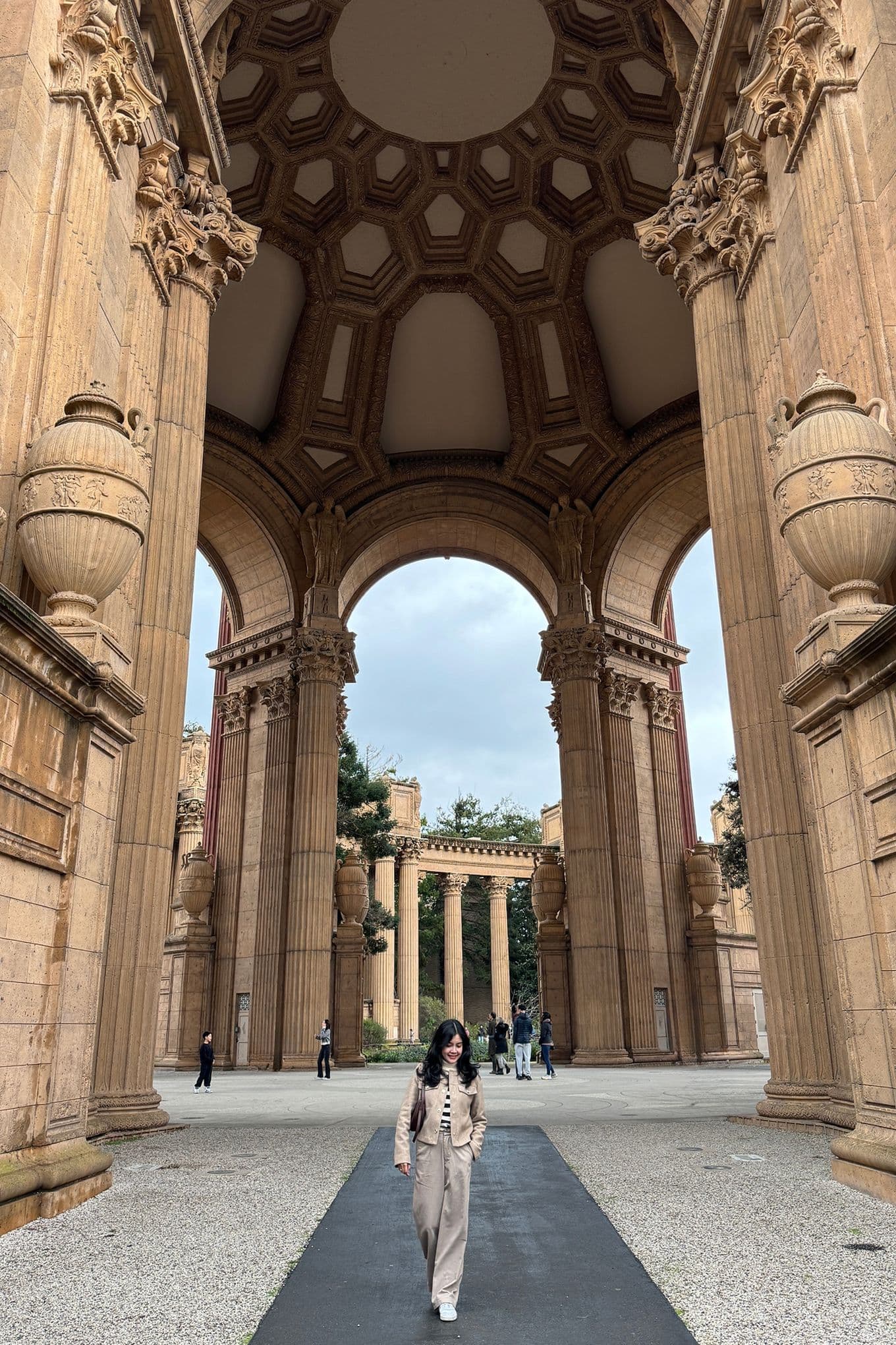 A woman walking underneath the Dome at the Palace of Fine Arts, San Francisco