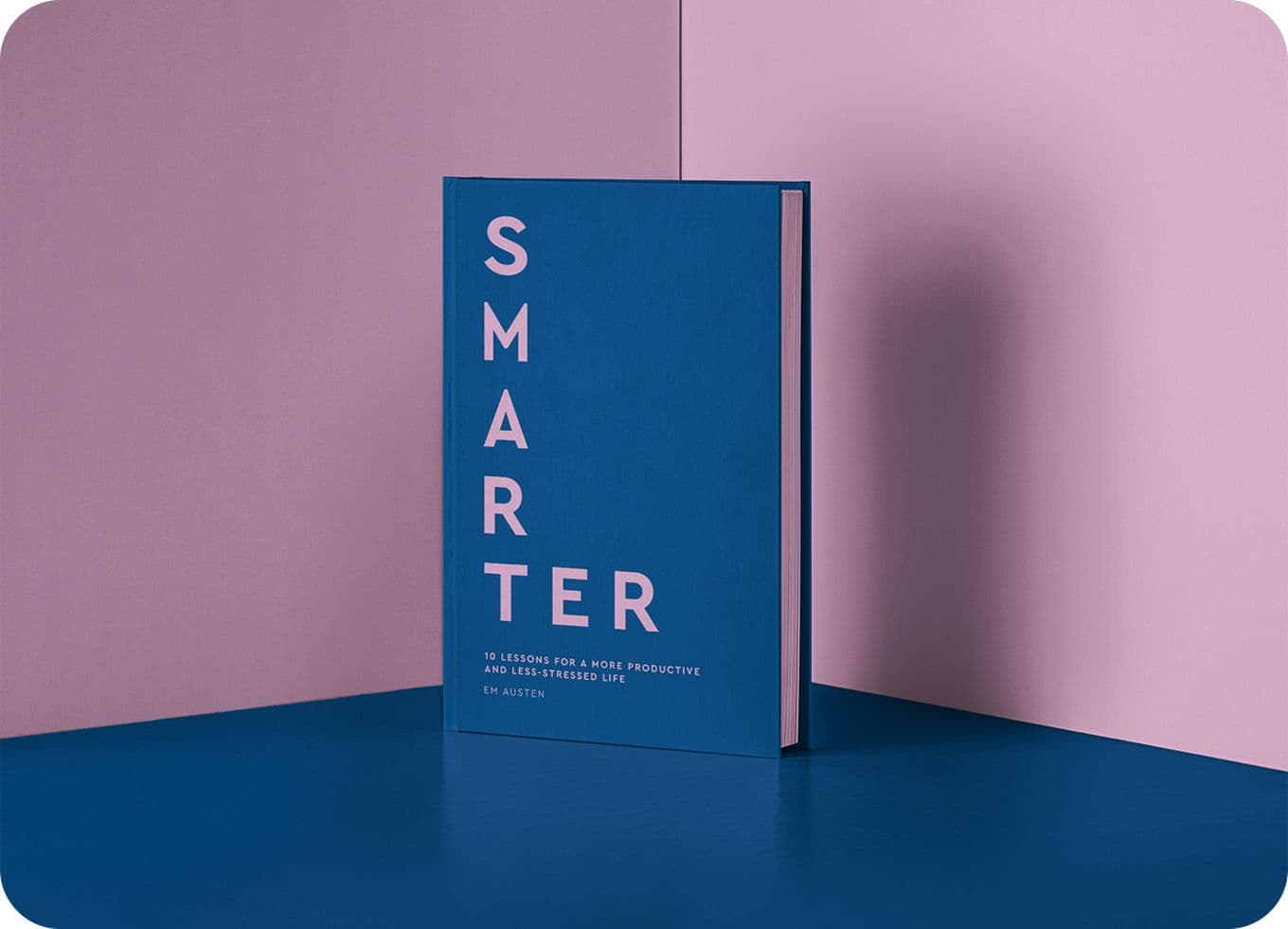 Blue book titled "SMARTER" stands upright against a two-toned pink and blue background.