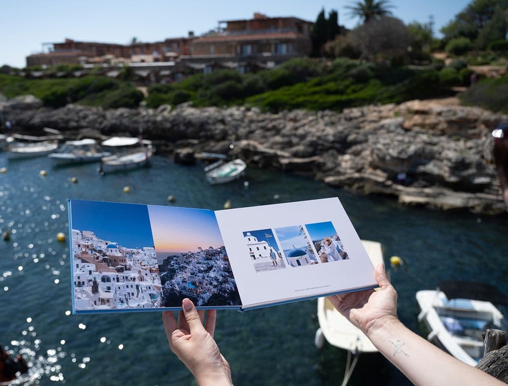 Hardcover layflat photo book with holiday images pictured against shimmering water
