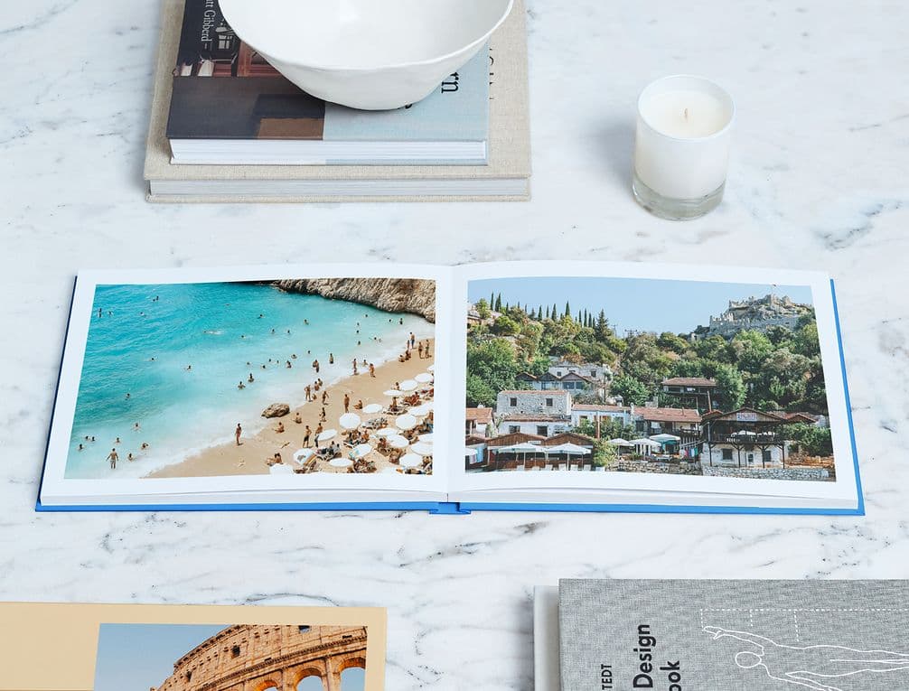 Personalised travel flatlay photo book with beach and landscape images