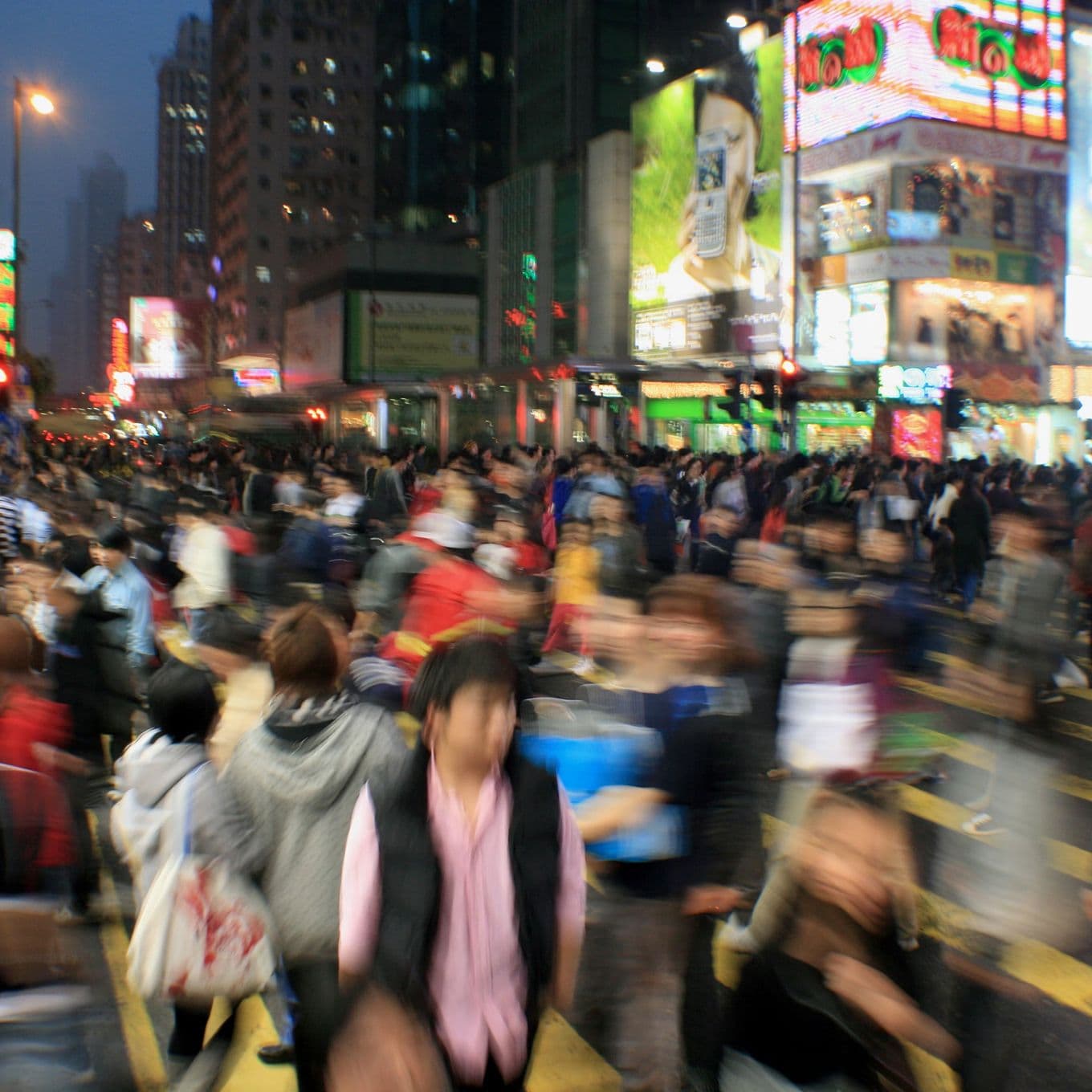 Crowds of tourists walking through a city at nighttime