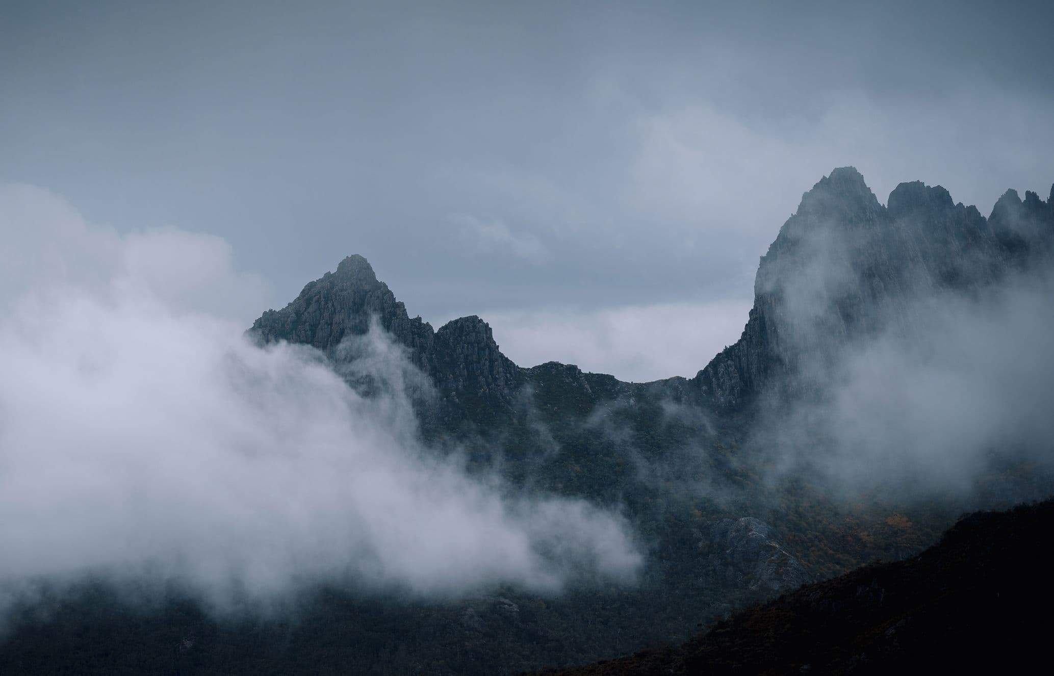 Clouds move past jagged mountain peaks