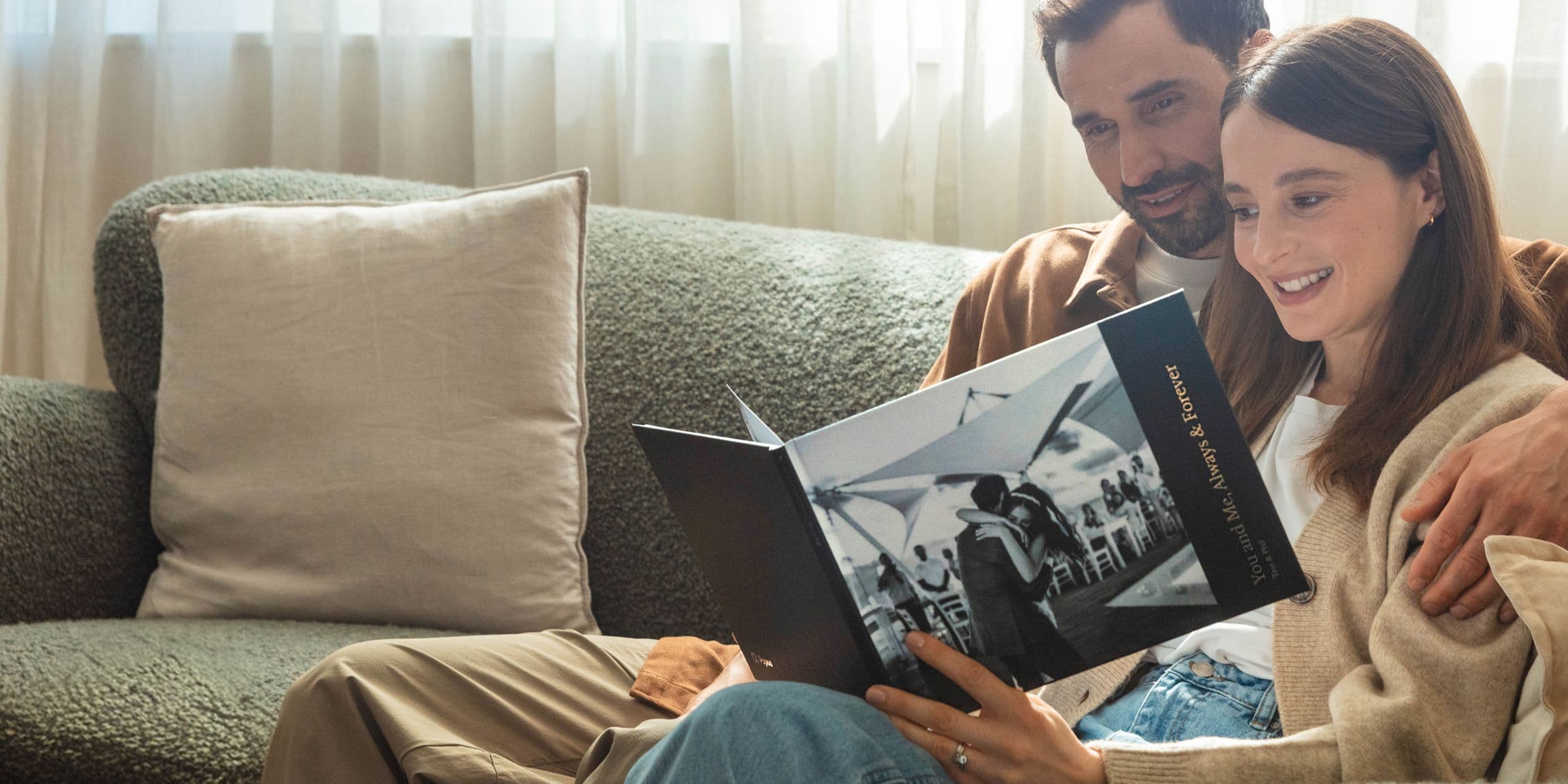 A couple looking at a hardcover photo book of their wedding
