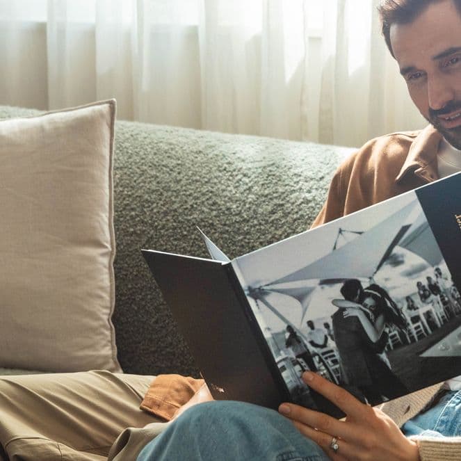 A couple looking at a hardcover photo book of their wedding