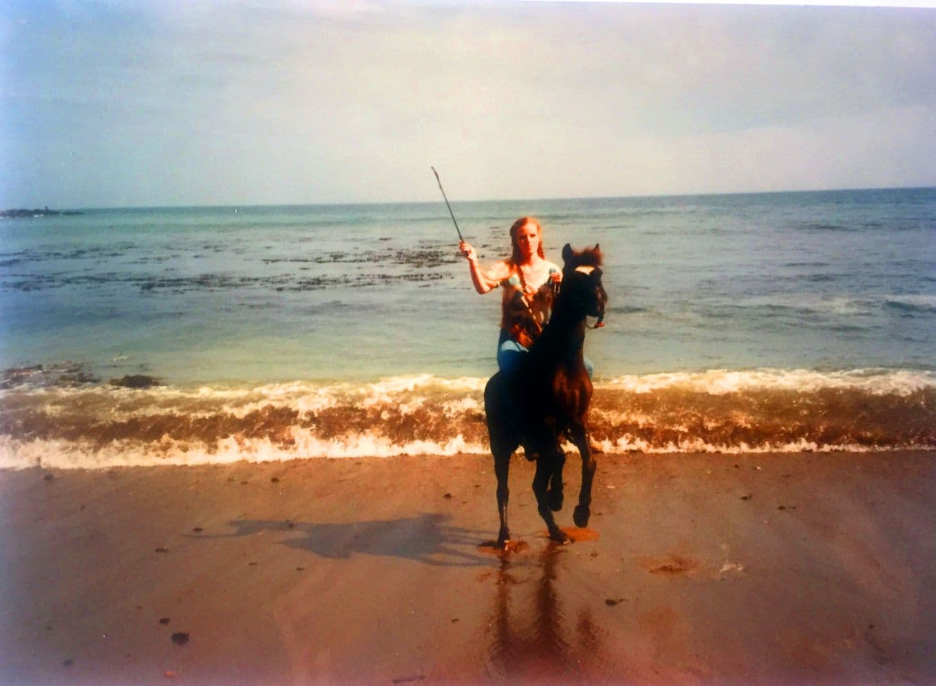 A young Staci Layne Wilson riding her pony, Smokey, on the beach