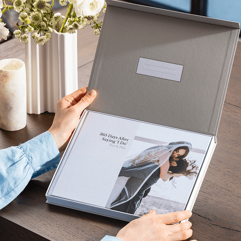 An anniversary-themed Popsa Photo Book with a newlywed couple on the front cover, in a premium presentation box