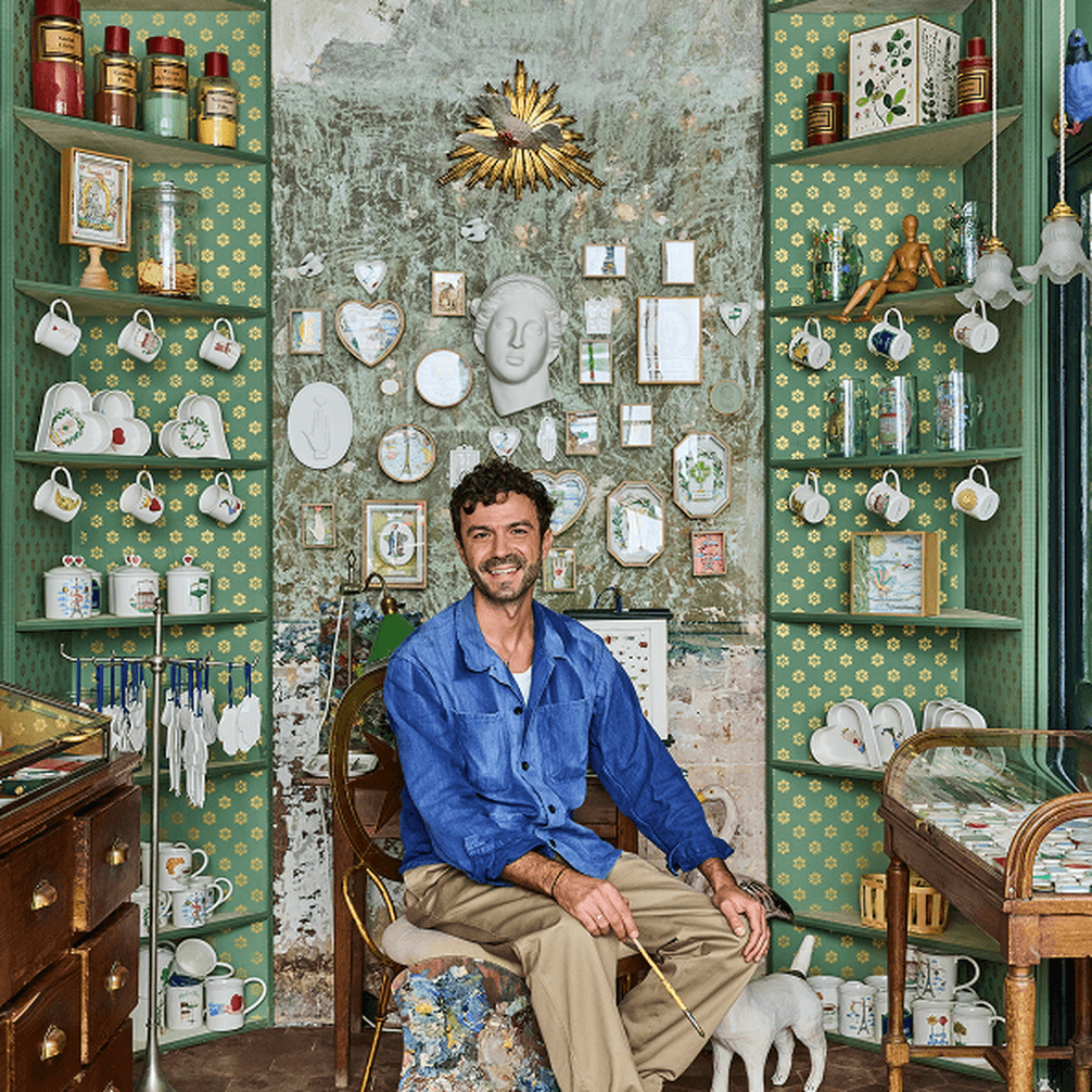 Portrait of Marin Montagut sat on chair with backdrop of ceramics