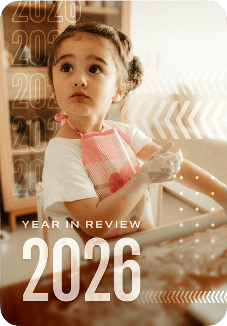 Young girl in a pink apron, hands covered in flour, looks to the side in a warm-lit kitchen. Text reads "Year in Review 2026."