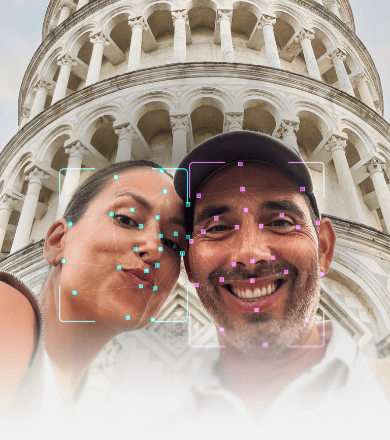 A couple taking a selfie in front of the Leaning Tower of Pisa, with facial recognition technology overlaying their faces.