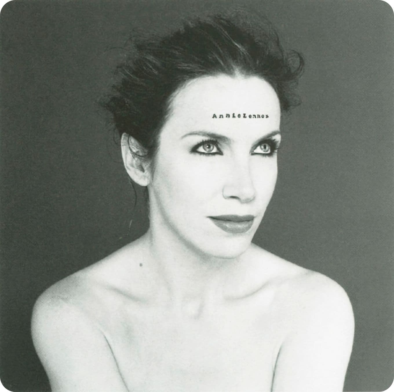 Black and white portrait of Annie Lennox with short hair and striking eyes, looking upwards. Text on her forehead reads "Annie Lennox."