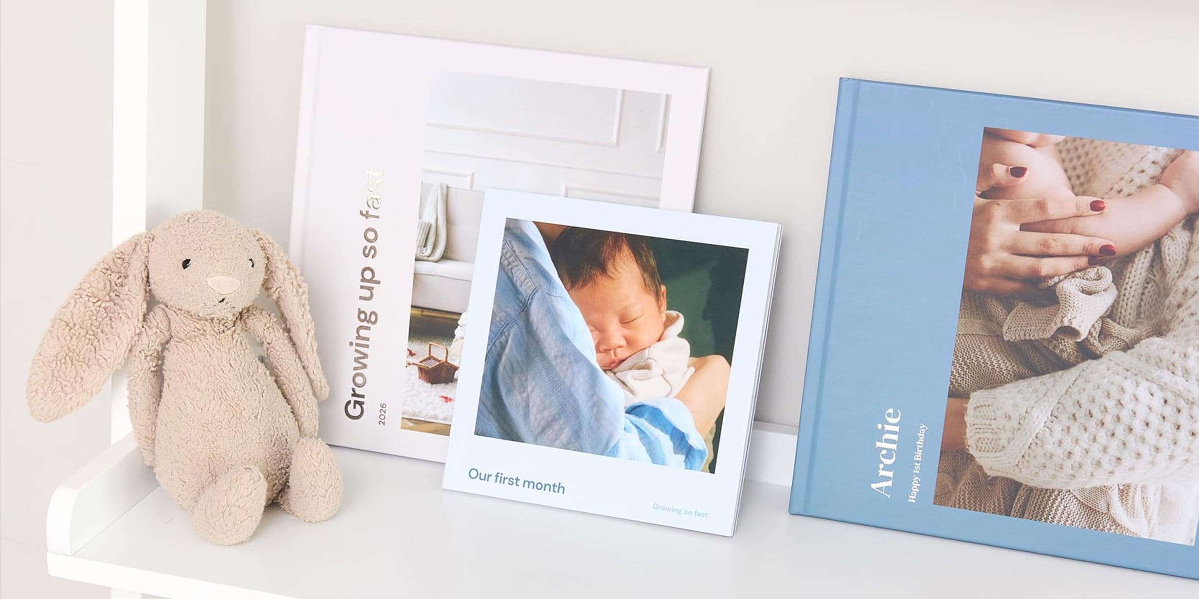A collection of hardcover and softcover photo books of newborn memories