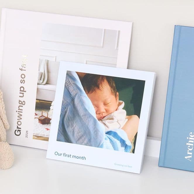 A collection of hardcover and softcover photo books of newborn memories