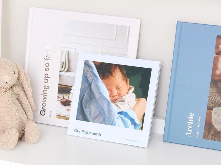 A collection of hardcover and softcover photo books of newborn memories