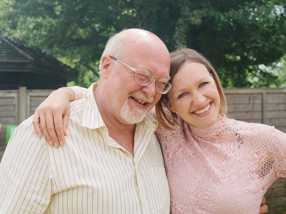 Father and daughter cuddling at outdoor birthday party