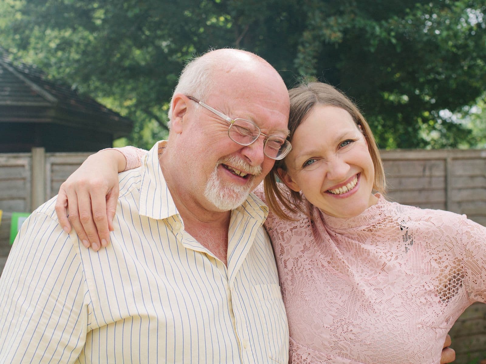 Father and daughter cuddling at outdoor birthday party