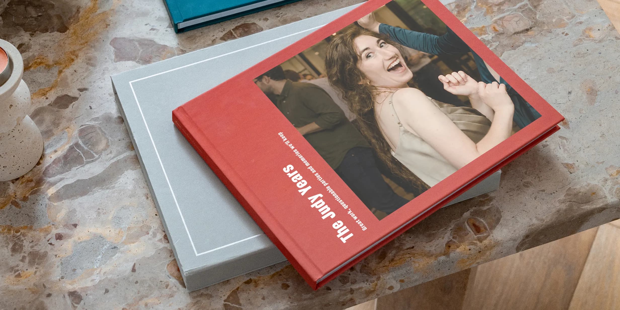 A red book titled "The Judy Years" with a joyful woman on the cover, placed on a gray book atop a marbled surface.
