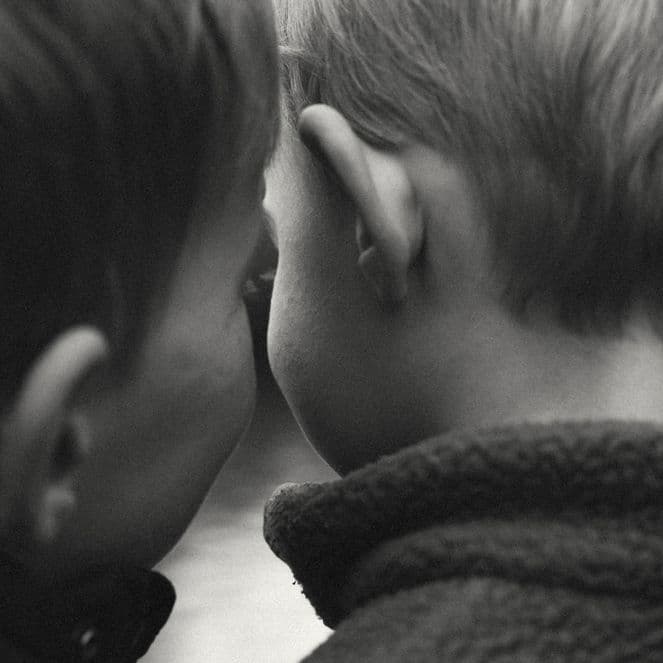 black and white photo of children's heads from the back