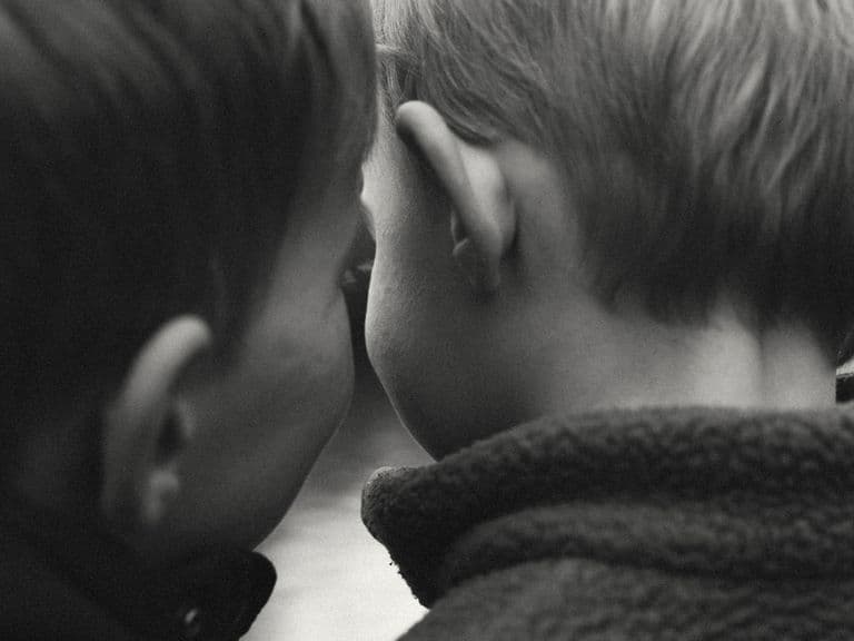 black and white photo of children's heads from the back