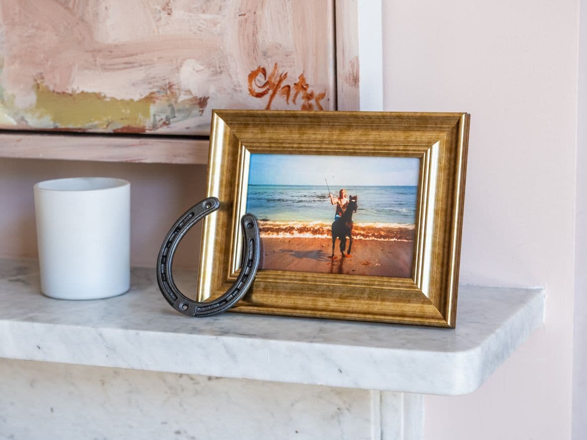 A framed photo of a young Staci Layne Wilson riding her pony, Smokey, on the beach