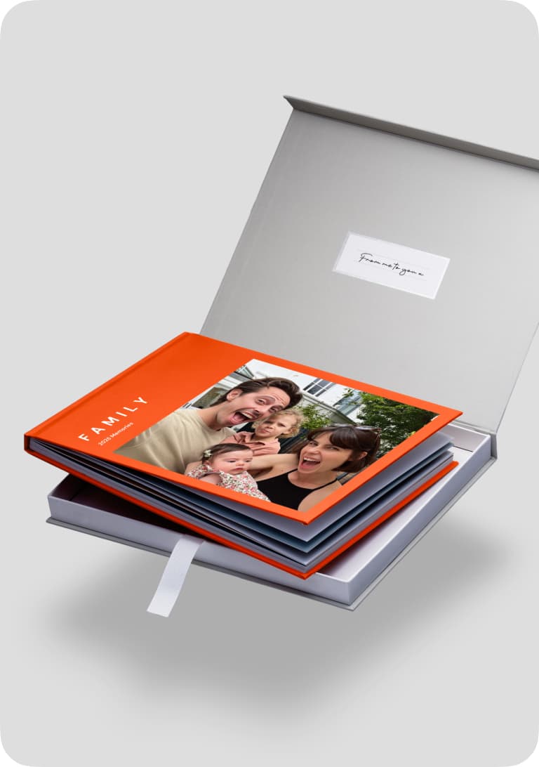 Open photo book with a family picture on the cover, inside a gray box with a white label.