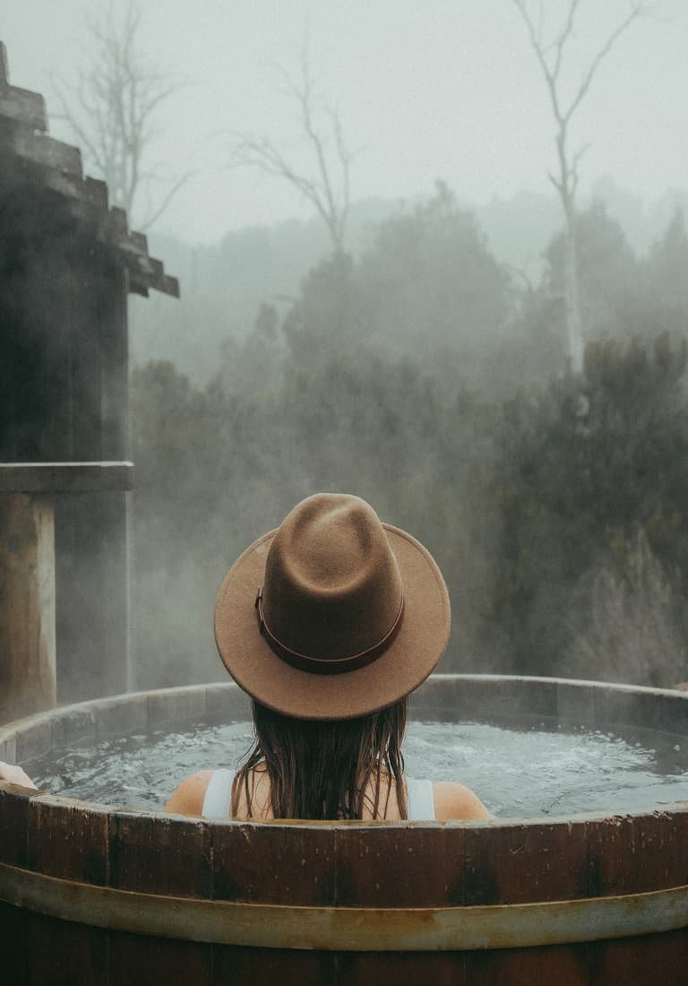 A woman in hot tub with steam rising from the chill of the air
