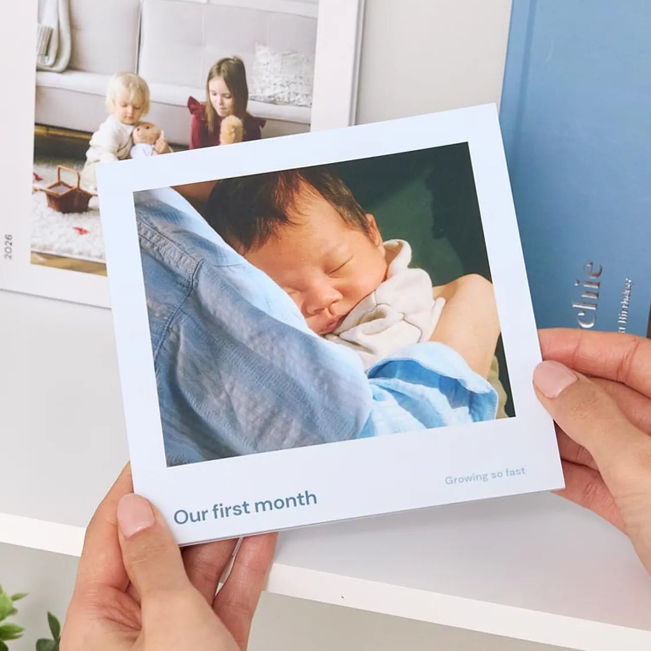 Photo booklet titled Our first month, with a photo of a sleeping baby on the cover