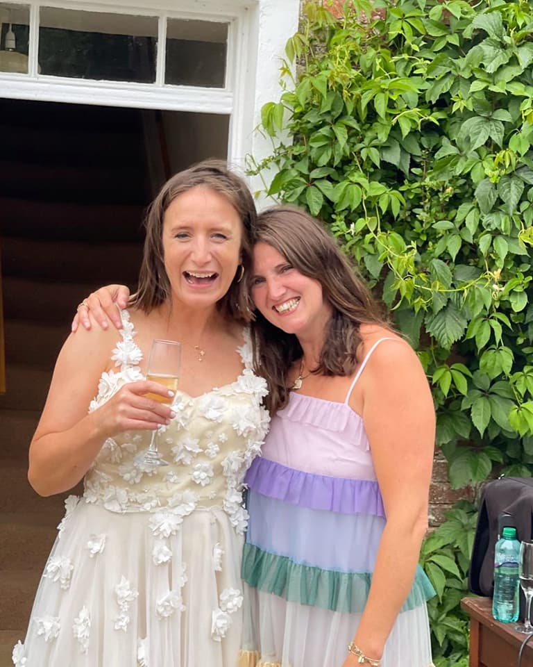 Two women smiling at a wedding