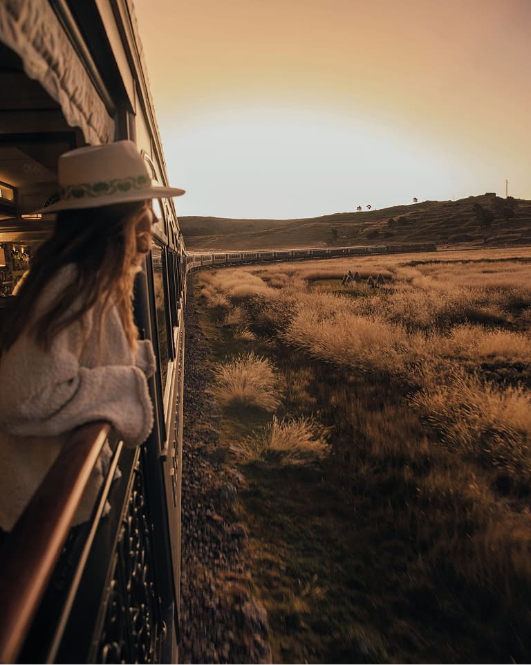 Woman looks out an open-air window on Belmond's Andean Explorer