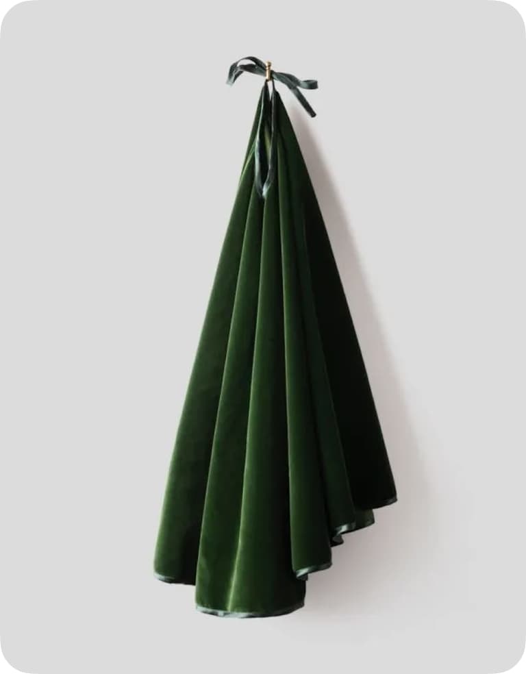 Dark green velvet fabric elegantly draped and hung on a wall, secured with a black ribbon.